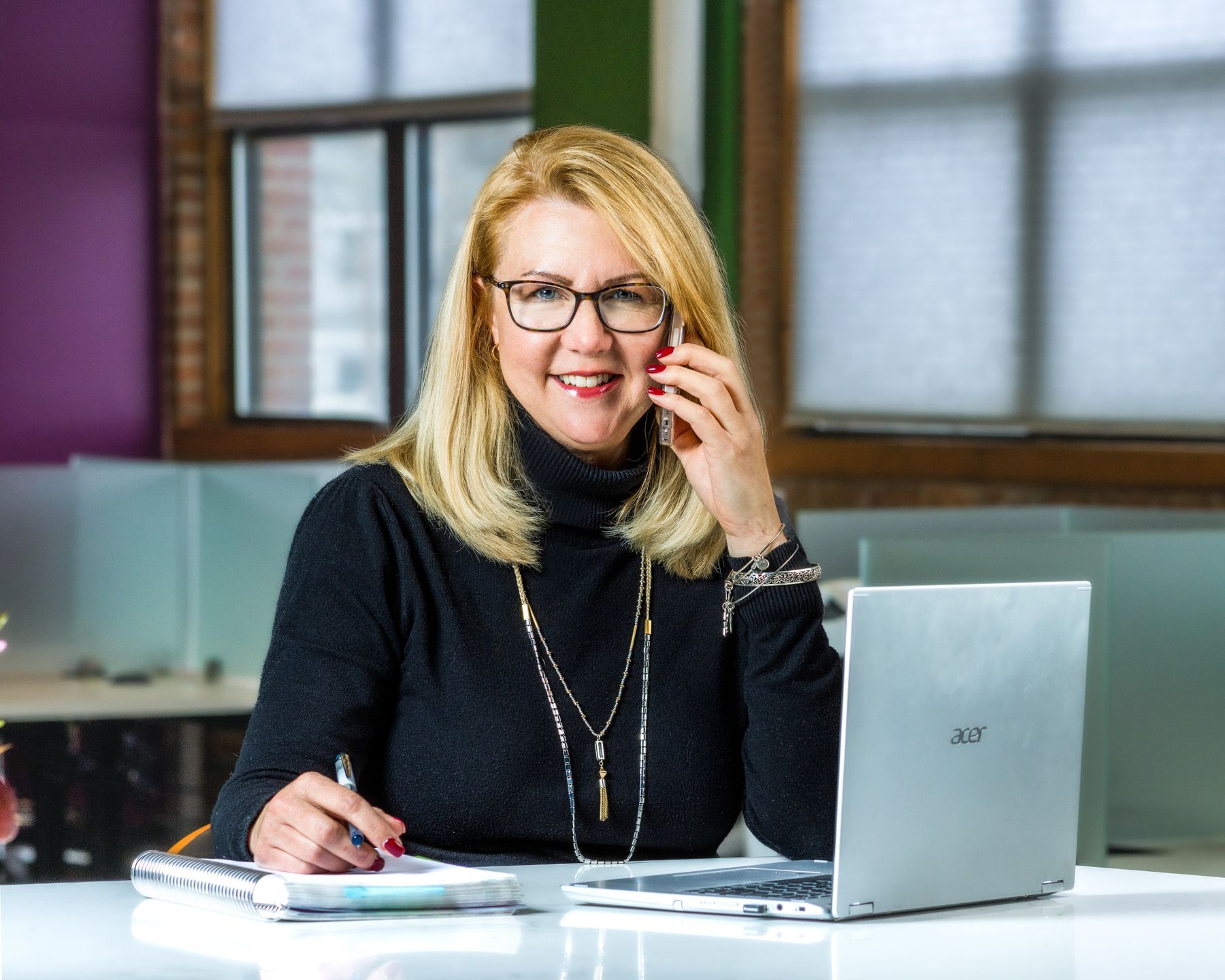 Professional speaking on the phone while working at a laptop